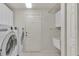 Laundry room with washer, dryer, utility sink, and built-in shelving at 5873 Macaw Pl, Lakeland, FL 33809