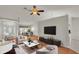 Living room with hardwood floors, staged furniture and a large TV at 5873 Macaw Pl, Lakeland, FL 33809