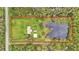 Aerial view showing house, detached garage, and pond at 9240 Moore Rd, Lakeland, FL 33809