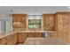 Updated kitchen with wood cabinets, granite countertops, and a double sink at 9240 Moore Rd, Lakeland, FL 33809