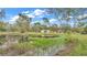 Tranquil pond view with a dock and home in background at 9240 Moore Rd, Lakeland, FL 33809