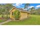 Yellow storage shed with a paved walkway and lush landscaping at 9240 Moore Rd, Lakeland, FL 33809
