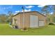 Tan metal workshop with large roll-up door and covered patio area at 9240 Moore Rd, Lakeland, FL 33809