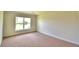 Simple carpeted bedroom with large window and neutral walls at 1226 Tagliamento Ln, Haines City, FL 33844