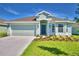 Single-story home with a two-car garage and landscaping at 1226 Tagliamento Ln, Haines City, FL 33844