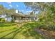 House exterior and large backyard with trees at 150 Woodcrest Ln, Mulberry, FL 33860