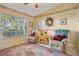 Relaxing den with two armchairs, a wooden cabinet and large window at 150 Woodcrest Ln, Mulberry, FL 33860