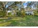 Spacious front yard with lush landscaping and mature oak tree at 150 Woodcrest Ln, Mulberry, FL 33860