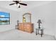 Bright bedroom with lake view, dresser, and ceiling fan at 2199 Ontario Way, Lakeland, FL 33805
