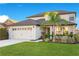 Two-story house with a two-car garage, lush landscaping, and a palm tree at 2199 Ontario Way, Lakeland, FL 33805