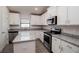 Modern kitchen with white cabinets, granite countertops, and stainless steel appliances at 4437 Juliana Lake Dr, Auburndale, FL 33823