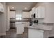 Modern kitchen with white cabinets, granite countertops, and stainless steel appliances at 4437 Juliana Lake Dr, Auburndale, FL 33823