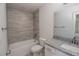 Clean bathroom with shower/tub combo, granite vanity, and gray tile at 4443 Juliana Lake Dr, Auburndale, FL 33823