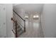 Staircase with wooden railing and gray tiled floor in entryway at 4443 Juliana Lake Dr, Auburndale, FL 33823