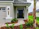 Front entrance with black door, brick walkway, and landscaping at 4443 Juliana Lake Dr, Auburndale, FL 33823