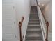 Modern staircase with wood railing and gray carpet at 4443 Juliana Lake Dr, Auburndale, FL 33823