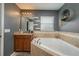 Bathroom featuring a corner soaking tub and granite vanity at 5791 Woodruff Way, Lakeland, FL 33812