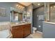 Bathroom with granite countertop, large mirror, and walk-in shower at 5791 Woodruff Way, Lakeland, FL 33812