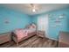 Light blue bedroom with twin bed and wood flooring at 5791 Woodruff Way, Lakeland, FL 33812