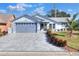 Single-story home with gray paver driveway and landscaped front yard at 6243 Egret Dr, Lakeland, FL 33809