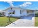 White single-wide manufactured home with covered carport and paved driveway at 6683 Briarhill Ne Dr, Winter Haven, FL 33881