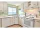 Efficient kitchen with white cabinets, appliances, and tile floor at 6683 Briarhill Ne Dr, Winter Haven, FL 33881