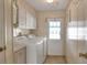 Bright laundry room features washer, dryer, cabinets, and exterior access at 6683 Briarhill Ne Dr, Winter Haven, FL 33881