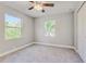 Bright bedroom with carpet, ceiling fan, and two windows at 711 N Nashua Ave, Fort Meade, FL 33841