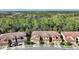 Aerial perspective of townhouses nestled in a wooded community with paved roads at 8205 Roseville, Davenport, FL 33896