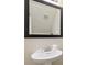 Simple bathroom with a pedestal sink, mirror, and bright white fixtures at 8205 Roseville, Davenport, FL 33896