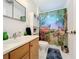 Bright bathroom with double vanity, shower/tub combo, and whimsical shower curtain at 309 W Frederick Ave, Dundee, FL 33838