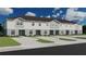 Three-unit townhouse building with light-grey siding and neutral landscaping at 313 Wharf Way, Winter Haven, FL 33881
