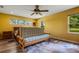 Main bedroom with yellow walls, a futon, and wood flooring at 1730 Broken Arrow N Trl, Lakeland, FL 33813