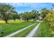 Long driveway leading to charming house with lush landscaping at 1730 Broken Arrow N Trl, Lakeland, FL 33813