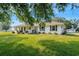 Single story home with white siding, large yard, and mature trees at 1730 Broken Arrow N Trl, Lakeland, FL 33813