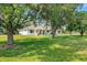 White house exterior with landscaping and large trees at 1730 Broken Arrow N Trl, Lakeland, FL 33813