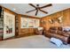 Sunroom with wood-paneled walls, ceiling fan, and comfortable seating at 1730 Broken Arrow N Trl, Lakeland, FL 33813