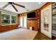 Sunroom with wood-paneled walls, French doors, and a large TV at 1730 Broken Arrow N Trl, Lakeland, FL 33813
