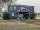Two-story house with covered patio, grassy yard, and tropical plants at 1918 Wind Meadows Dr, Bartow, FL 33830
