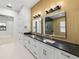 Bathroom with double vanity, wood wall, and access to bedroom at 2728 Sunrise Landing Ln, Lakeland, FL 33812