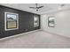 Spacious bedroom with dark-grey accent wall, ceiling fan, and ample natural light at 2728 Sunrise Landing Ln, Lakeland, FL 33812
