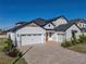 Two-story home with white siding, stone accents, and a three-car garage at 2728 Sunrise Landing Ln, Lakeland, FL 33812