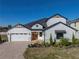 Two-story home with white siding, stone accents, and a three-car garage at 2728 Sunrise Landing Ln, Lakeland, FL 33812