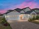 Stunning two-story home at dusk, showcasing its architectural details and landscaping at 2728 Sunrise Landing Ln, Lakeland, FL 33812