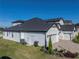 Rear view of home showcasing the three car garage and landscaping at 2728 Sunrise Landing Ln, Lakeland, FL 33812