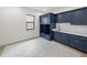 Laundry room with navy cabinets, quartz countertops, and patterned floor at 2728 Sunrise Landing Ln, Lakeland, FL 33812