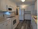 White kitchen cabinets, new appliances, and wood-look flooring at 1610 Reynolds Rd # 211, Lakeland, FL 33801