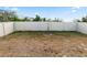 A fenced backyard featuring a small young tree and grass at 1754 Eagle Hammock Blvd, Eagle Lake, FL 33839