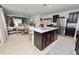 Open-concept kitchen and living area with an island, stainless steel appliances, and dark wood cabinetry at 1754 Eagle Hammock Blvd, Eagle Lake, FL 33839