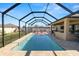 Screened-in pool area with outdoor kitchen and patio at 303 Lake Mariana Pl, Auburndale, FL 33823